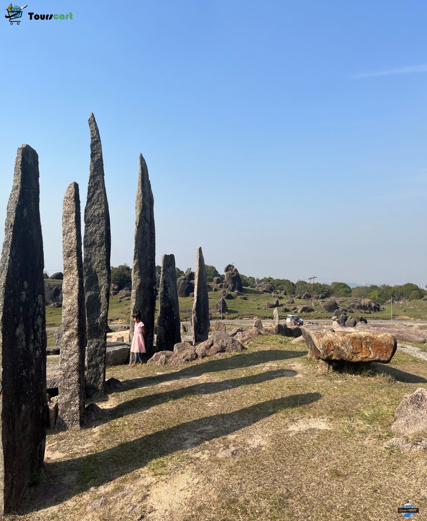 The iconic Khasi stone monoliths standing tall under the clear blue sky, a significant cultural and historical site in Meghalaya.